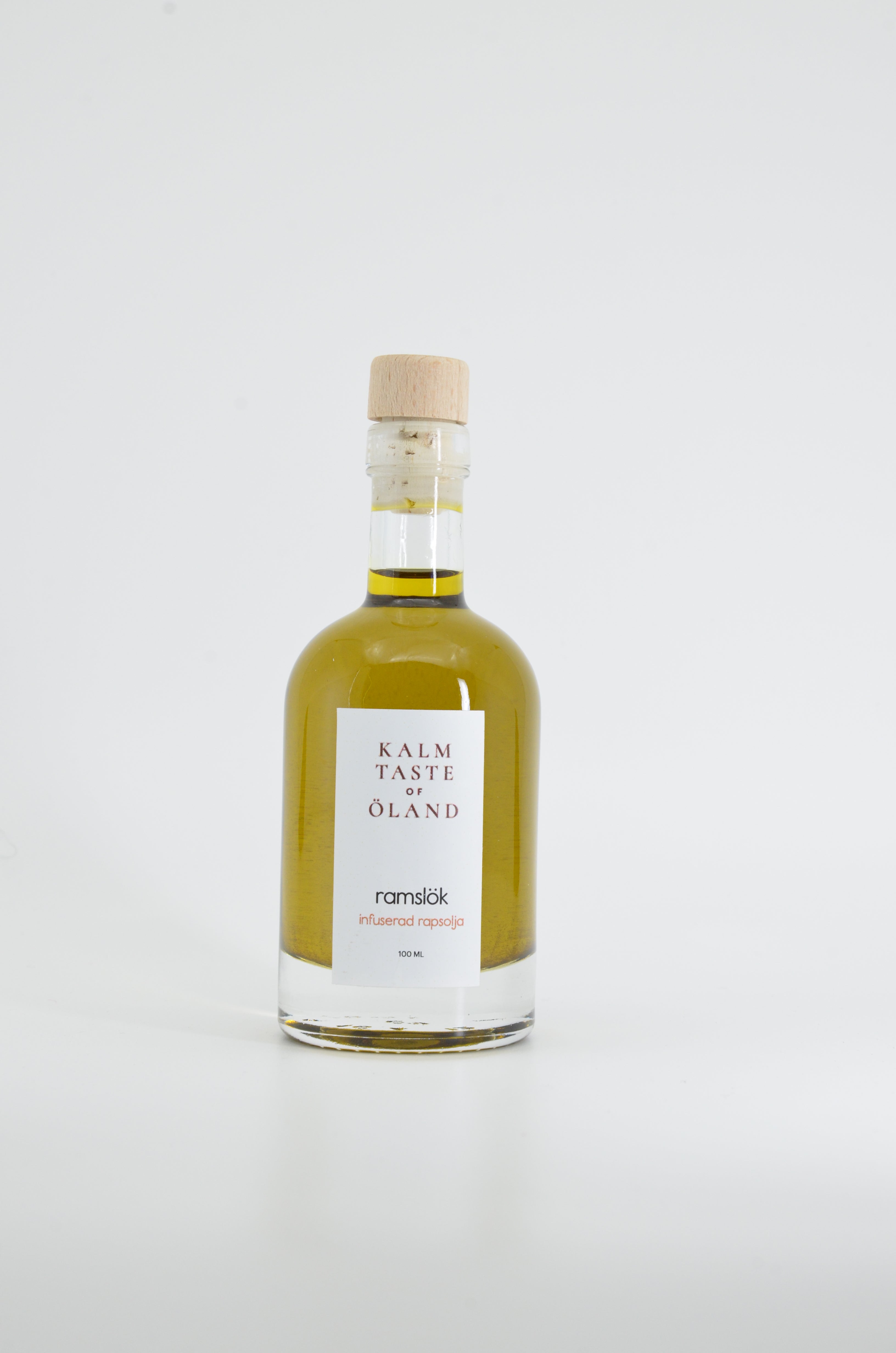 Flaska med Kalm Taste Ramslökolja – smaksatt rapsolja med färsk ramslök, småskaligt producerad i Kastlösa på Öland utan tillsatser eller bekämpningsmedel.