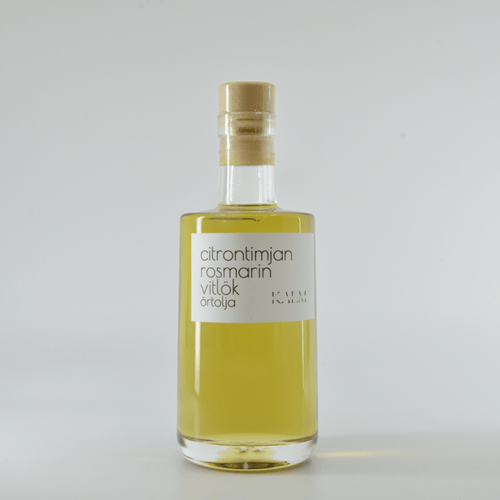 Flaska med Kalm Taste örtolja smaksatt med citrontimjan, rosmarin och vitlök – småskaligt producerad på Öland utan tillsatser eller bekämpningsmedel.