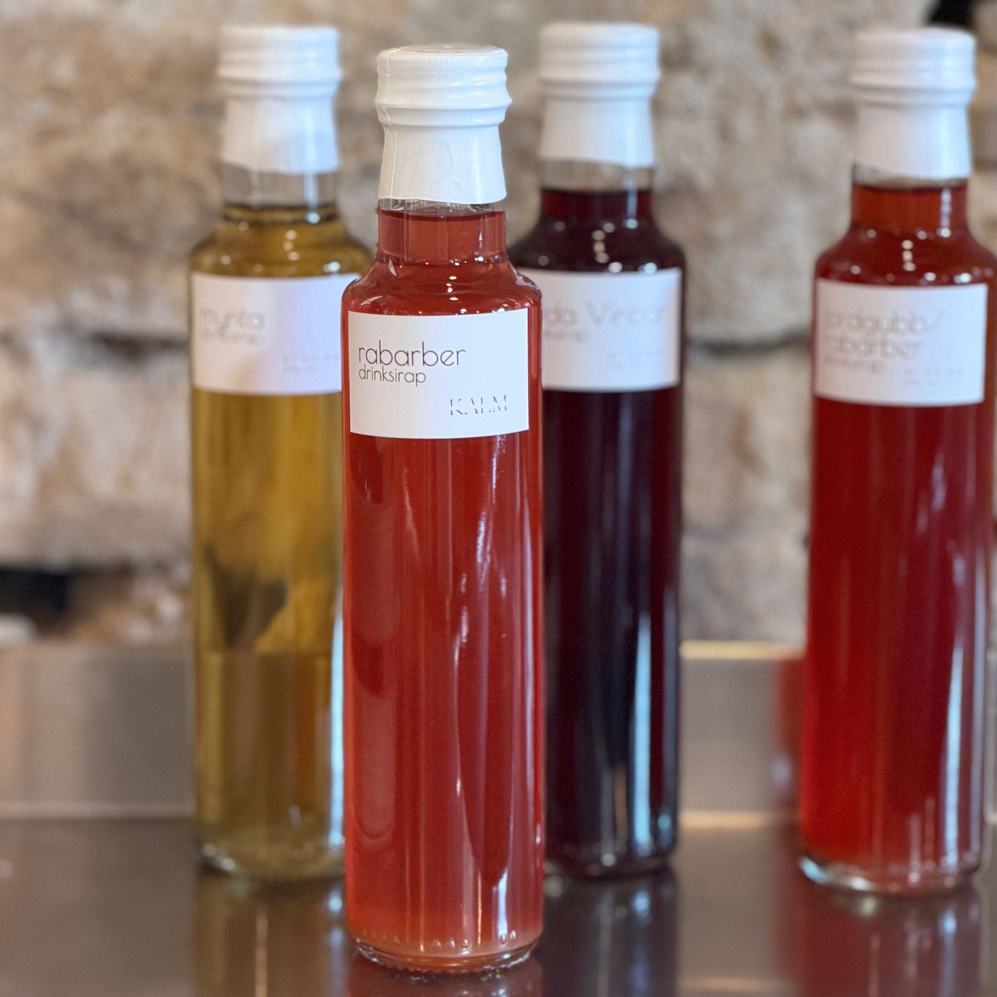Flaska med handgjord rabarberdrinksirap från Kalm Taste Öland, framtagen för drinkar, mocktails och sommardrycker.