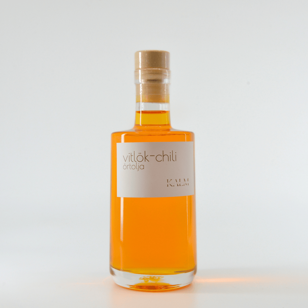 Flaska med Kalm Taste Chili/Vitlök-olja – smaksatt rapsolja med chili och vitlök, hantverksmässigt producerad utan tillsatser på gård i Kastlösa, Öland.