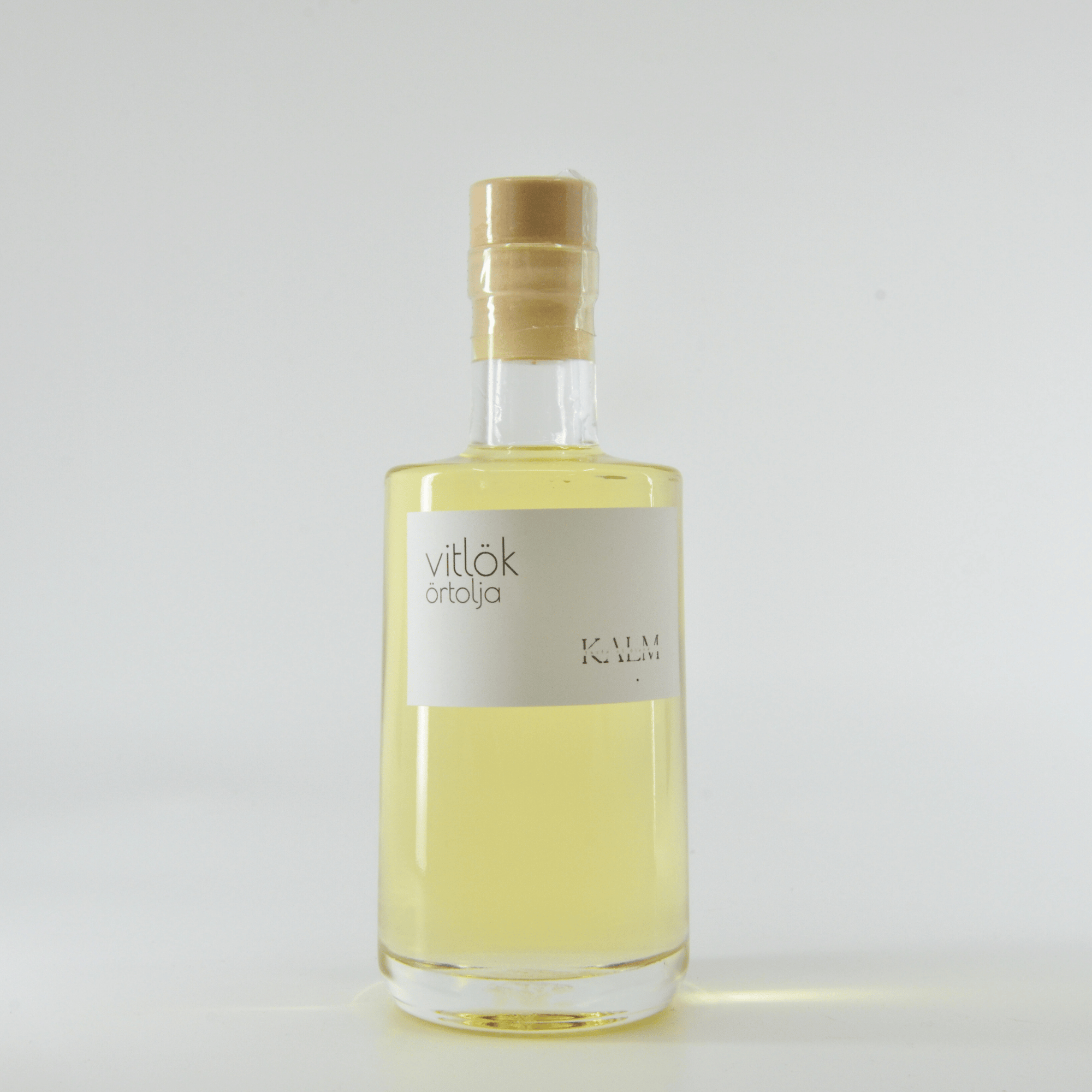 Flaska med Kalm Taste Vitlöksolja – smakrik, rostad vitlök i svensk rapsolja. Småskaligt producerad på Öland utan tillsatser eller bekämpningsmedel.