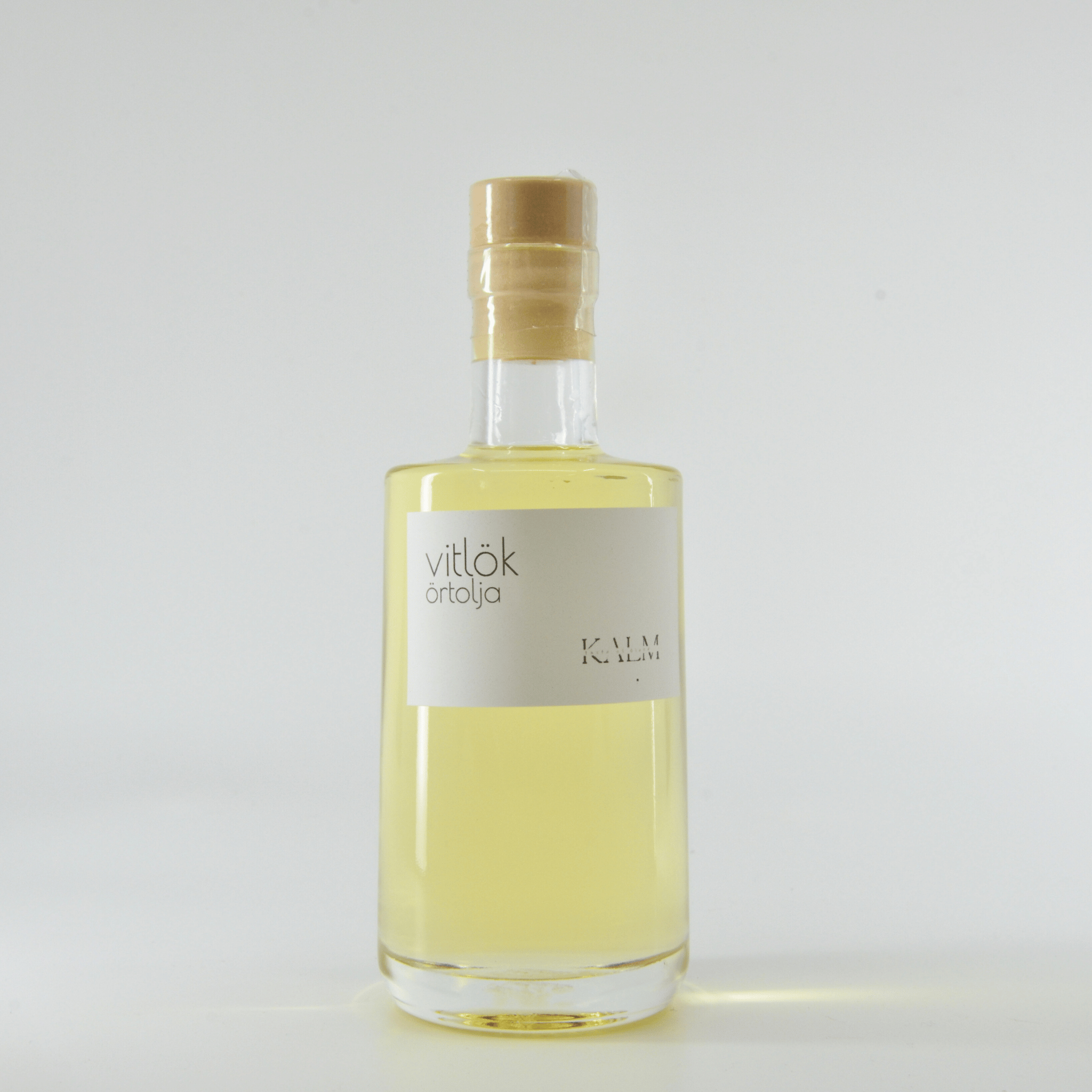 Flaska med Kalm Taste Vitlöksolja – smakrik, rostad vitlök i svensk rapsolja. Småskaligt producerad på Öland utan tillsatser eller bekämpningsmedel.